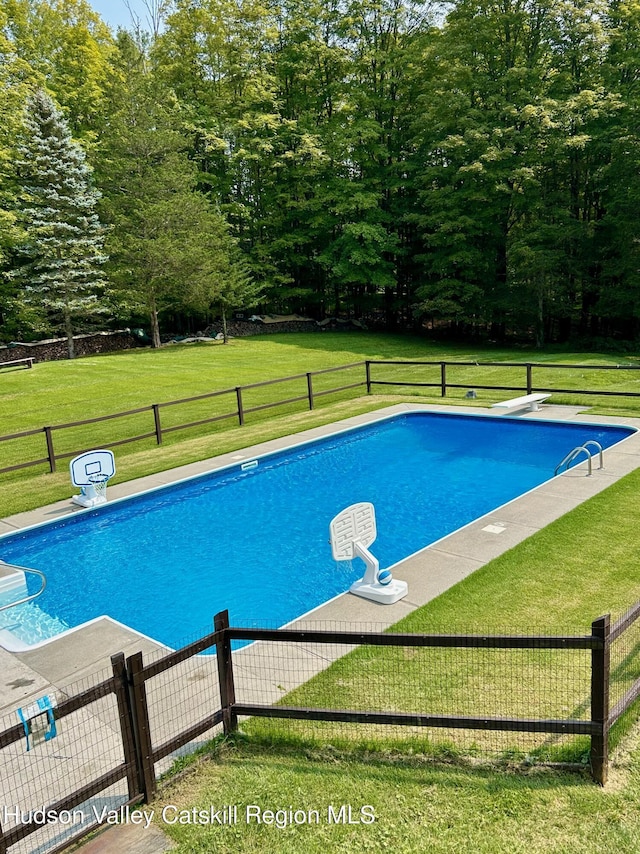 view of pool with a lawn