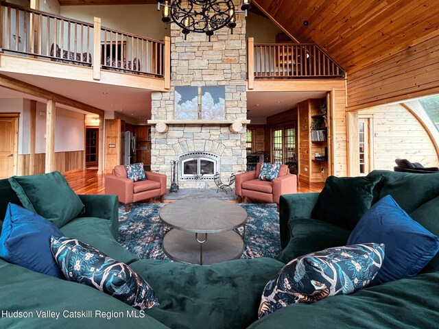 60 Leon Ln, Stony Creek, NY 12878 - living area featuring high vaulted ceiling, wood walls, a stone fireplace, wooden ceiling, and a chandelier