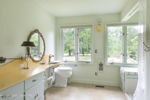 bathroom featuring sink, heating unit, and toilet