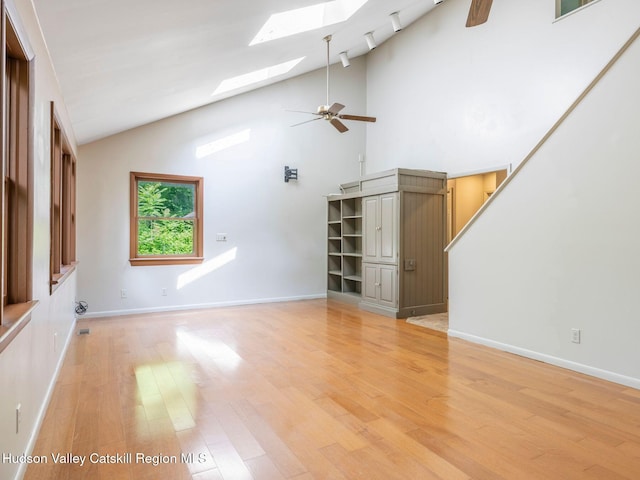 221 Cardinal Rd, Hyde Park, NY 12538 - unfurnished living room featuring a skylight, light wood finished floors, a ceiling fan, and high vaulted ceiling