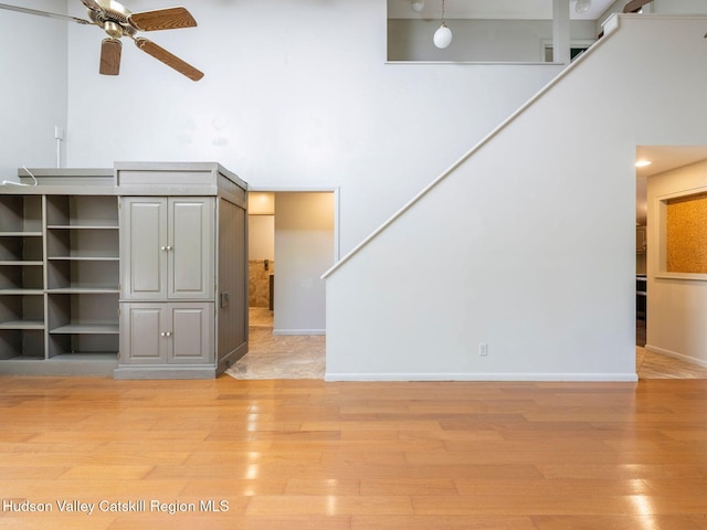 221 Cardinal Rd, Hyde Park, NY 12538 - unfurnished living room with ceiling fan, light wood-style flooring, stairs, and a high ceiling