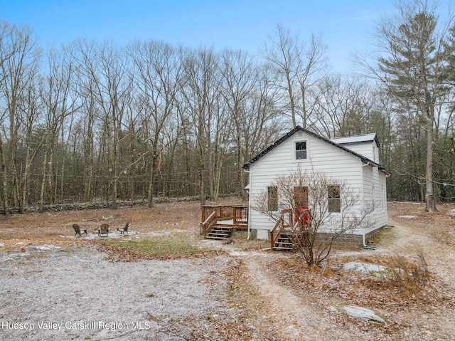 view of property exterior with a wooden deck