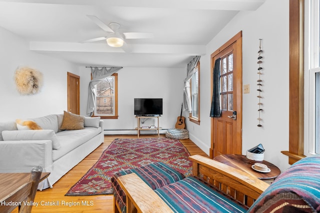 living room with baseboard heating, ceiling fan, and hardwood / wood-style floors