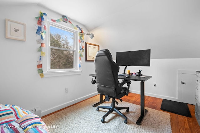 office area with a baseboard radiator, lofted ceiling, and hardwood / wood-style flooring