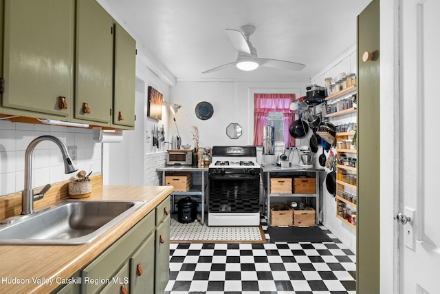 kitchen featuring green cabinets, sink, ceiling fan, tasteful backsplash, and white range with gas stovetop