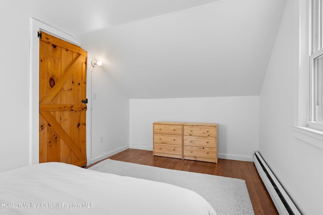 bedroom with lofted ceiling, dark wood-type flooring, and a baseboard heating unit