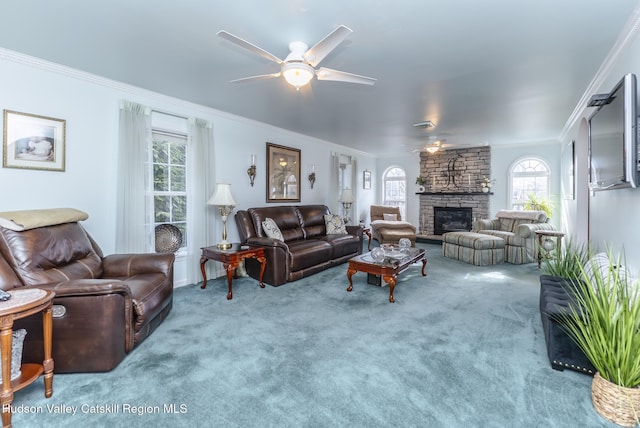 living room featuring a fireplace, crown molding, carpet, and ceiling fan