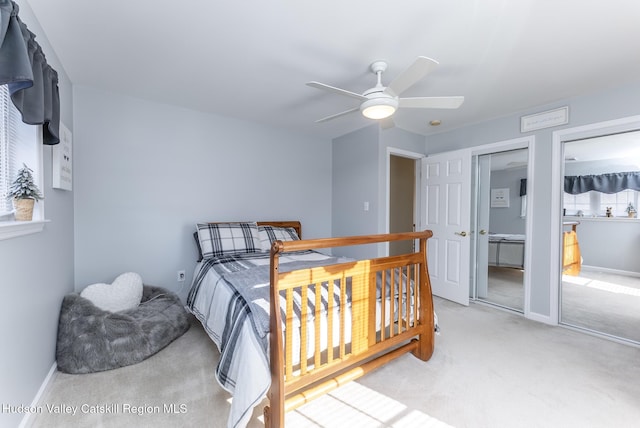 carpeted bedroom featuring a ceiling fan, baseboards, and multiple closets