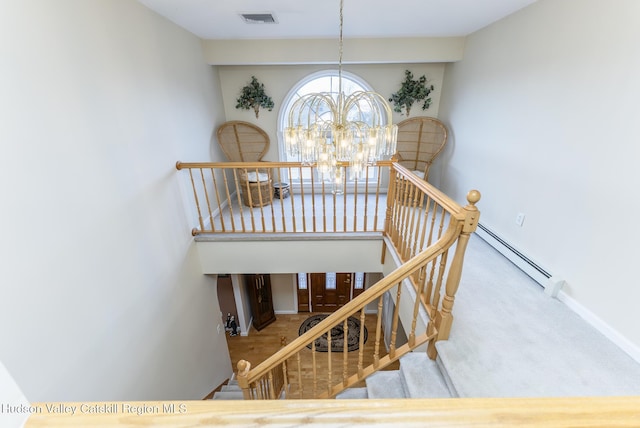 stairs featuring visible vents, baseboards, baseboard heating, and an inviting chandelier