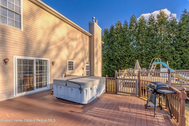 wooden deck with outdoor dining space and a hot tub