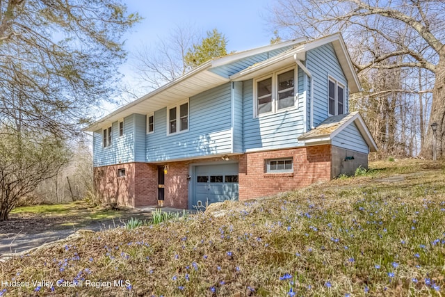 view of front facade featuring brick siding and an attached garage