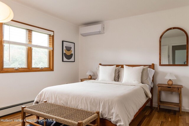 bedroom with crown molding, an AC wall unit, wood finished floors, and a baseboard radiator
