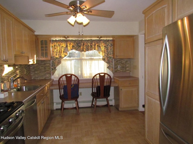 kitchen featuring backsplash, sink, appliances with stainless steel finishes, and a baseboard radiator