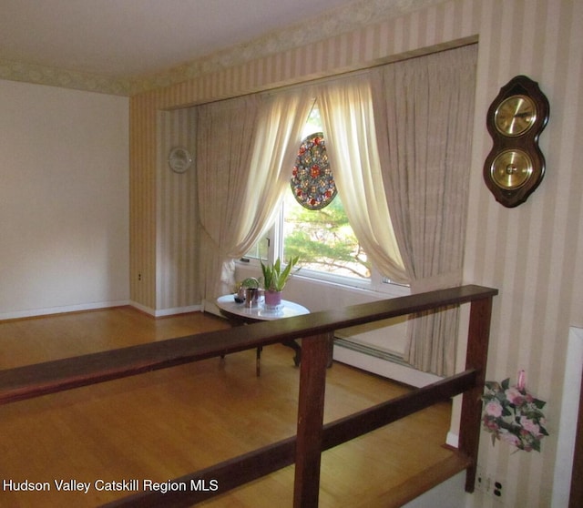 interior space with hardwood / wood-style floors and a baseboard heating unit