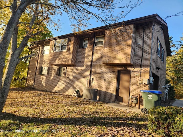 back of house featuring cooling unit and a garage