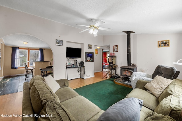 252 Ruby Rd, Kingston, NY 12401 - living room featuring arched walkways, wood finished floors, a wood stove, and a ceiling fan