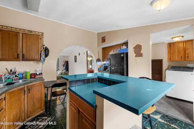252 Ruby Rd, Kingston, NY 12401 - kitchen featuring freestanding refrigerator, a kitchen breakfast bar, brown cabinetry, arched walkways, and a sink