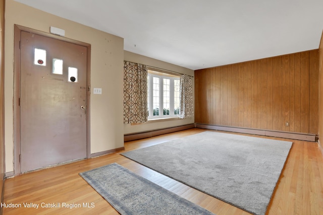 foyer with wooden walls and light hardwood / wood-style floors