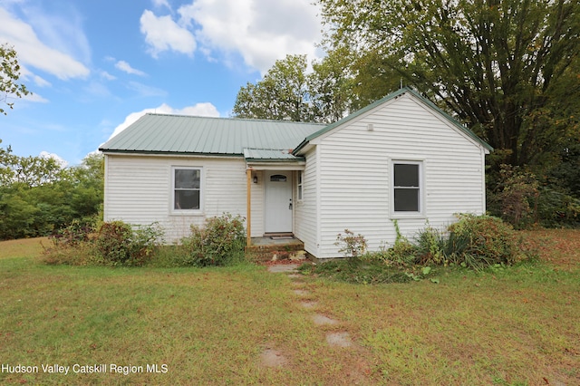 ranch-style house with metal roof and a front yard