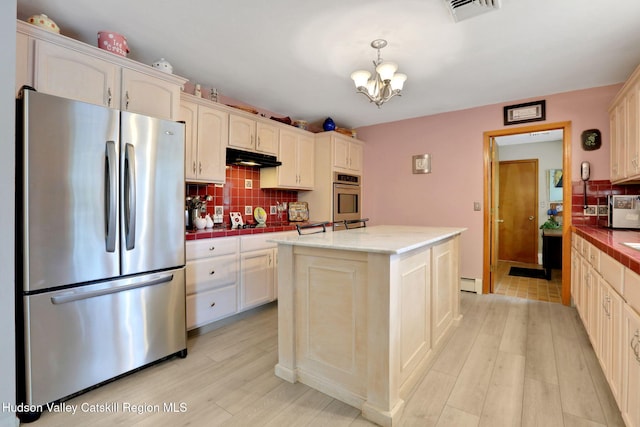 12 Roming Ln, Saugerties, NY 12477 - kitchen with stainless steel appliances, light wood-style floors, tasteful backsplash, and a chandelier