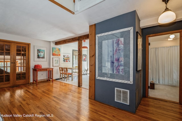 hall with french doors and hardwood / wood-style floors