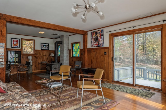 living room with hardwood / wood-style floors, wood walls, and a wood stove