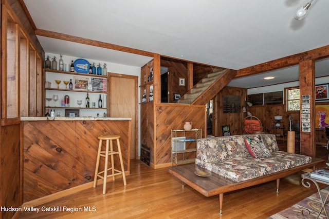 living room with hardwood / wood-style flooring and wood walls