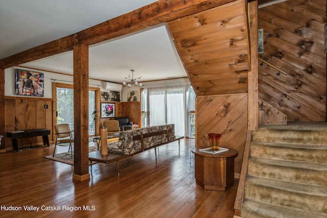 living room featuring a wealth of natural light, hardwood / wood-style floors, and an inviting chandelier