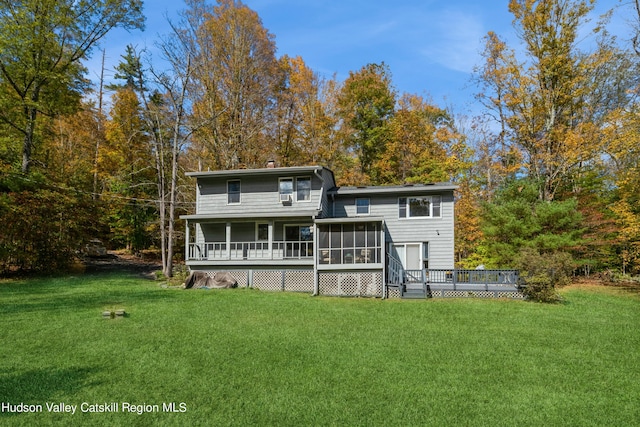 back of house featuring a yard, a deck, and a sunroom