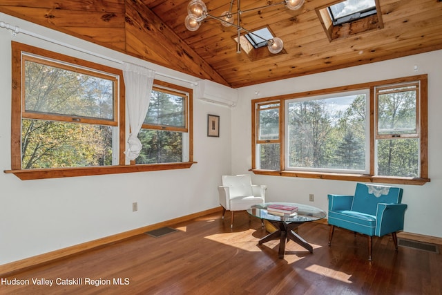 unfurnished room with hardwood / wood-style floors, plenty of natural light, lofted ceiling with skylight, and a wall mounted AC