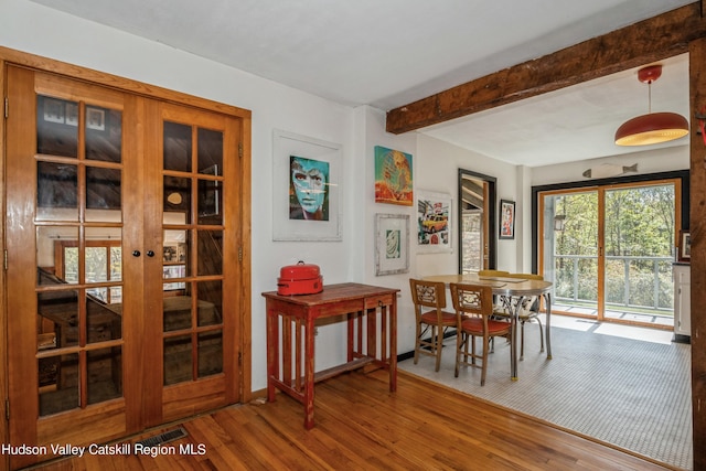 dining area featuring hardwood / wood-style floors, beamed ceiling, and french doors