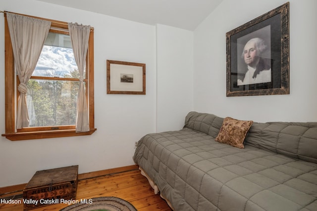 bedroom with vaulted ceiling and hardwood / wood-style flooring