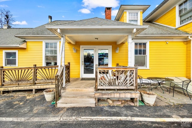 3630 Main St, Stone Ridge, NY 12484 - view of exterior entry featuring a deck, a chimney, and a shingled roof
