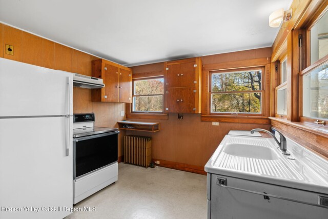 kitchen with radiator heating unit, white appliances, and sink