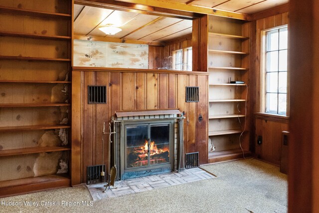 unfurnished living room with light carpet, wooden ceiling, and wooden walls