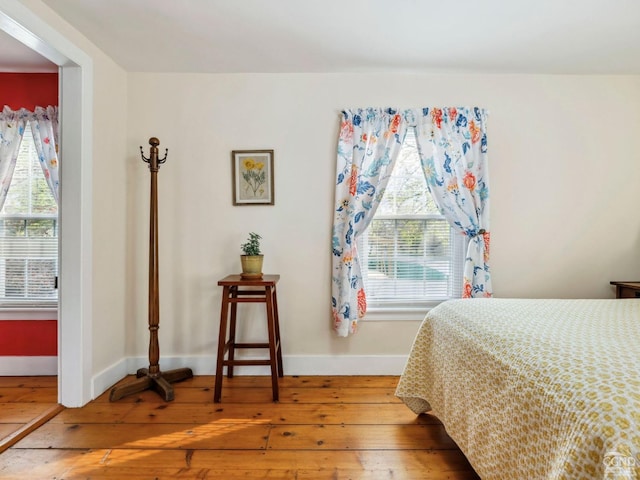 bedroom with hardwood / wood-style floors, multiple windows, and baseboards