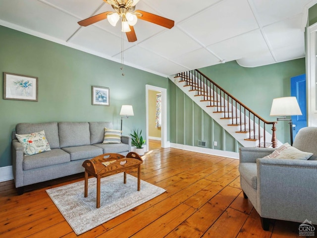 living room featuring wood-type flooring, baseboards, stairs, and ceiling fan