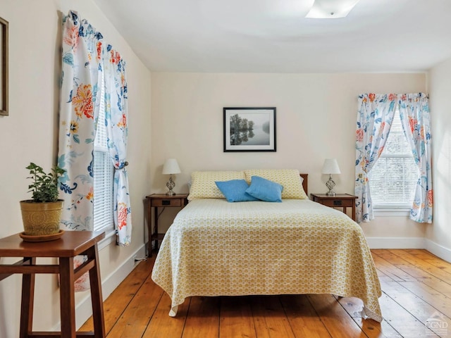 bedroom featuring wood-type flooring and baseboards