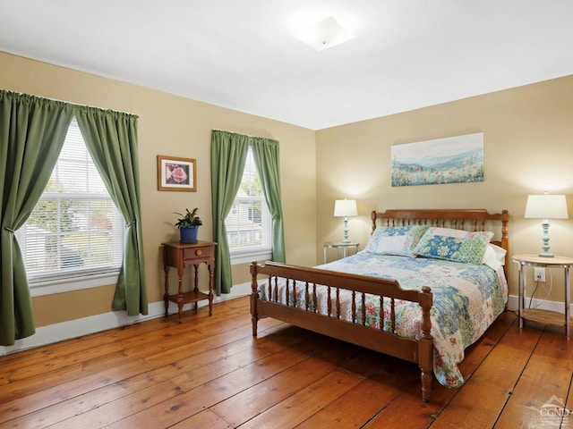 bedroom with hardwood / wood-style flooring and baseboards