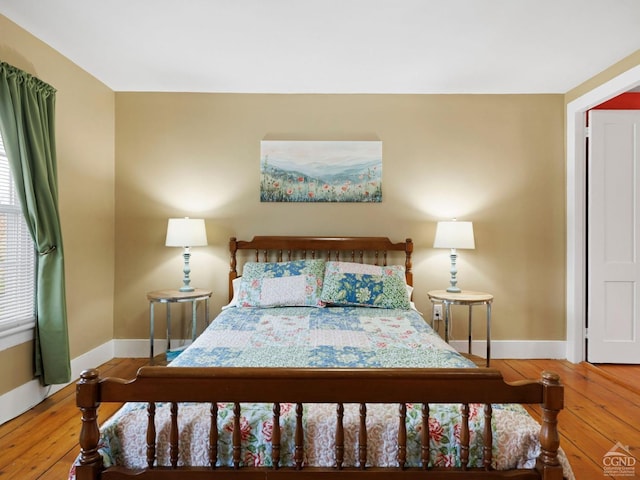 bedroom with baseboards and hardwood / wood-style floors