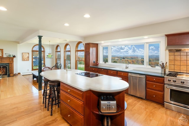 237 Christian Hill Rd, Cooperstown, NY 13326 - kitchen featuring appliances with stainless steel finishes, a sink, light wood-type flooring, a kitchen bar, and tasteful backsplash