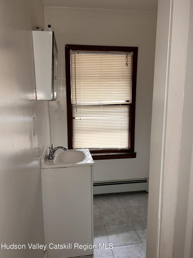 bathroom featuring vanity, baseboard heating, and tile patterned floors