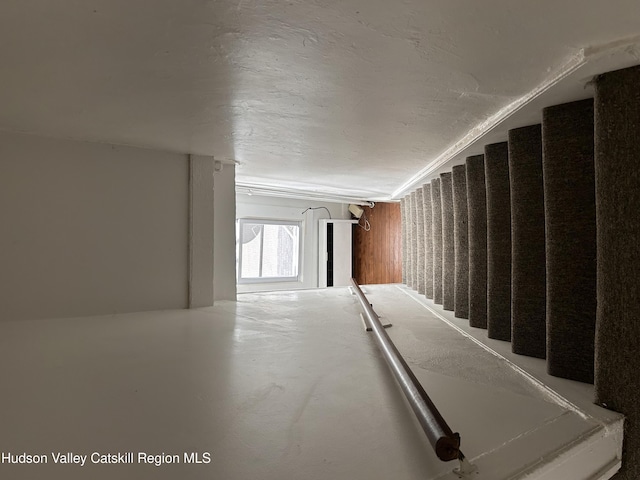 stairs featuring concrete flooring and a textured ceiling