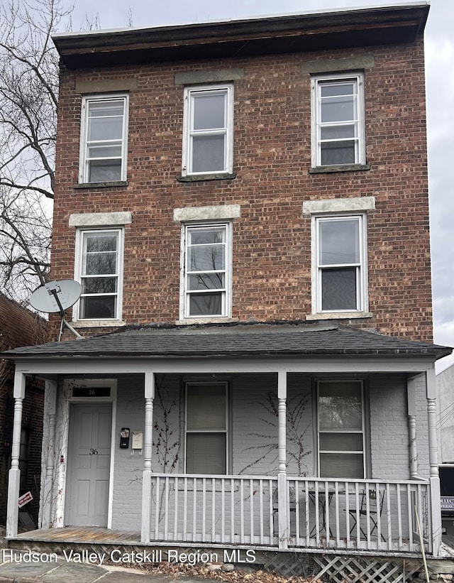 multi unit property featuring a porch and brick siding