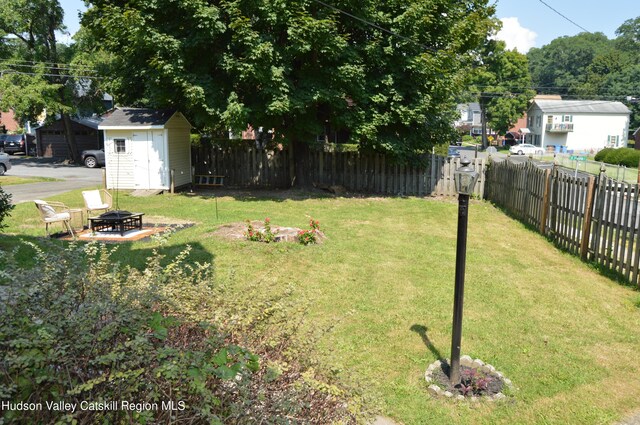 view of yard featuring a shed and a fire pit