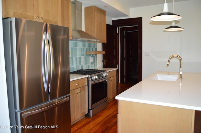kitchen with wall chimney range hood, sink, hanging light fixtures, dark hardwood / wood-style flooring, and stainless steel appliances