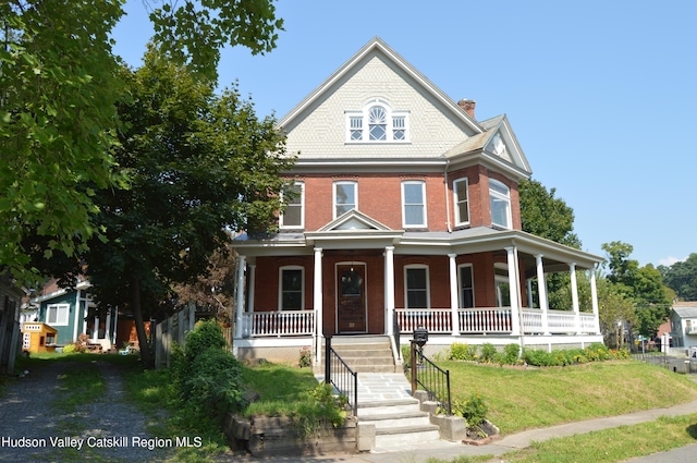 view of front of home with covered porch and a front yard
