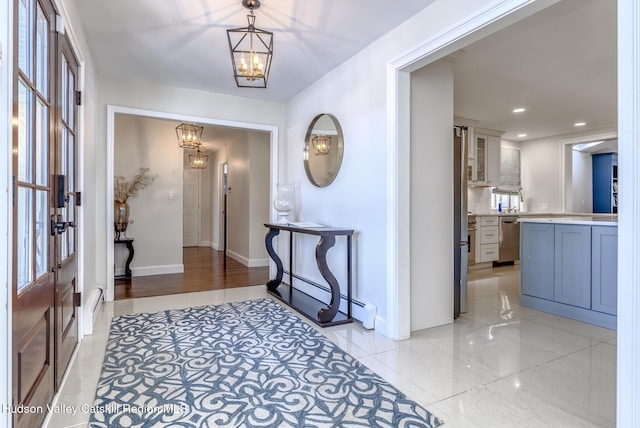 entrance foyer featuring recessed lighting, a baseboard heating unit, a notable chandelier, baseboards, and marble finish floor