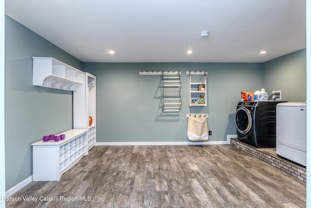 washroom featuring laundry area, baseboards, wood finished floors, independent washer and dryer, and recessed lighting