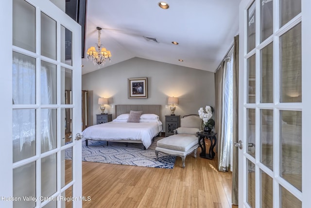 bedroom with visible vents, vaulted ceiling, wood finished floors, and french doors